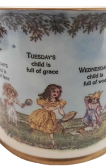 Monday's Child Mug. Short two handled mug with paintings of toys and children inside.